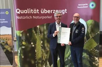 Der Präsident des Verbands Deutscher Naturparke (VDN), Friedel Heuwinkel, überreicht dem Geschäftsführer des Natur- und Geoparks Vulkaneifel, Andreas Schüller, die Urkunde als Qualitätsnaturpark. Insgesamt 19 Naturparke wurden am 18. September 2024 während der Mitgliederversammlung des Verbandes Deutscher Naturparke e. V. (VDN e. V.) im Naturpark Südschwarzwald für Ihre Qualitätsarbeit im Rahmen der „Qualitätsoffensive Naturparke“ ausgezeichnet.