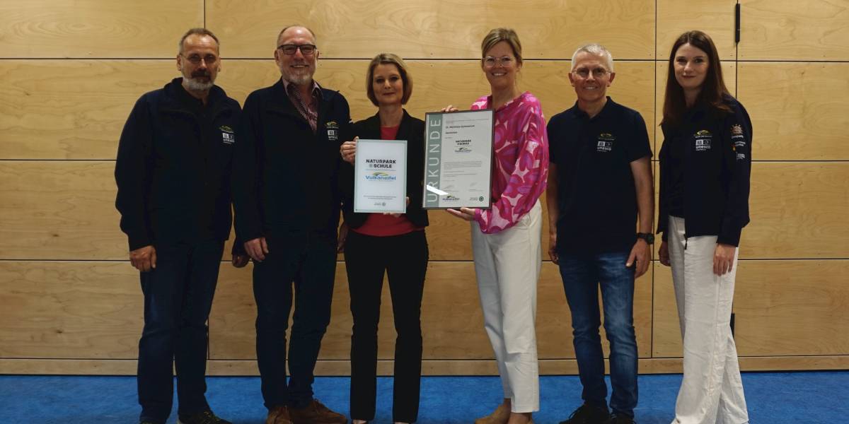 Bei der Zertifizierung und Überreichung der Urkunde waren die Schüler*innen der neunten Klassen, die Bläserklasse, Schulleiterin Claudia Schneiders, Landrätin Julia Gieseking, Kooperationskoordinator Ulrich Daniels sowie die Mitarbeiter*innen des Natur- und Geoparks Vulkaneifel Andreas Schüller, Achim Herf und Sabine Kummer vor Ort. 